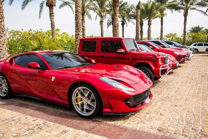 Dubaiban piros luxusautók sorakoznak, Ferrari, Porsche, Mercédesz.