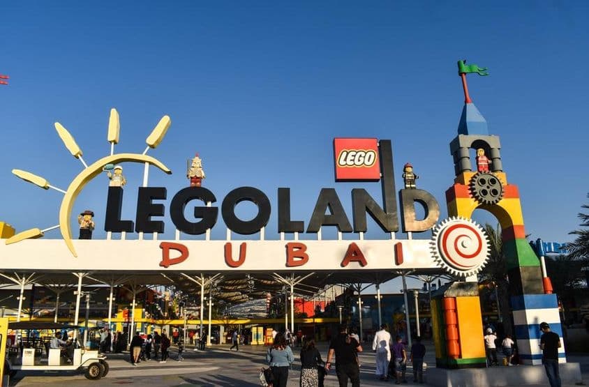 legoland Dubai bejárata látható, elötte emberek és egy golfkocsi.