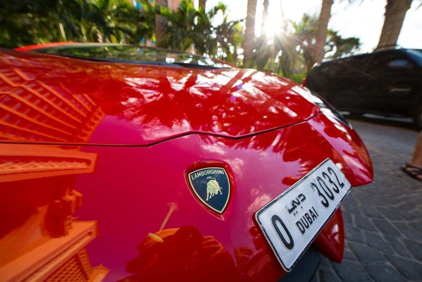 Egy Lamborghini piros színű, csak az eleje látszik rajta egy dubai 4 számból álló rendszám.