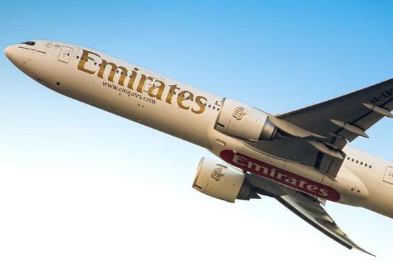 Emirates repülőgép a levegőben, alulról látható.
