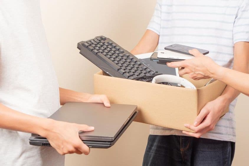 A képen laptopok, telefonok egyéb számítógép alkatrészek vannak amit épp eladományoznak.