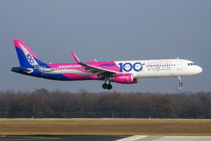 Wizz air gép repül kis magasságban a kifutó felett.