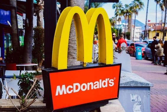 McDonalds táblája látható háttérben egy utca képpel.