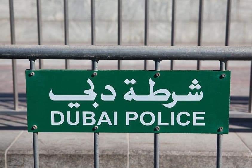 Dubaoi Police felirat olvasható egy kerítésen.
