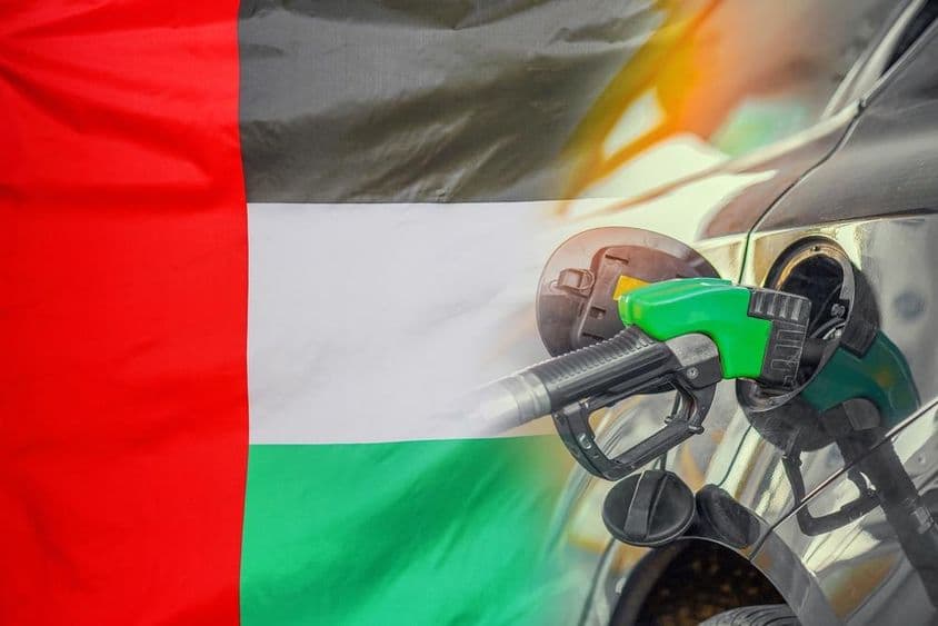 Háttérben UAE zászló, elől egy autó amit épp tankolnak benzinnel.