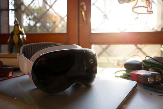 Apple Vision Pro fekszik egy notebookon egy asztalon.