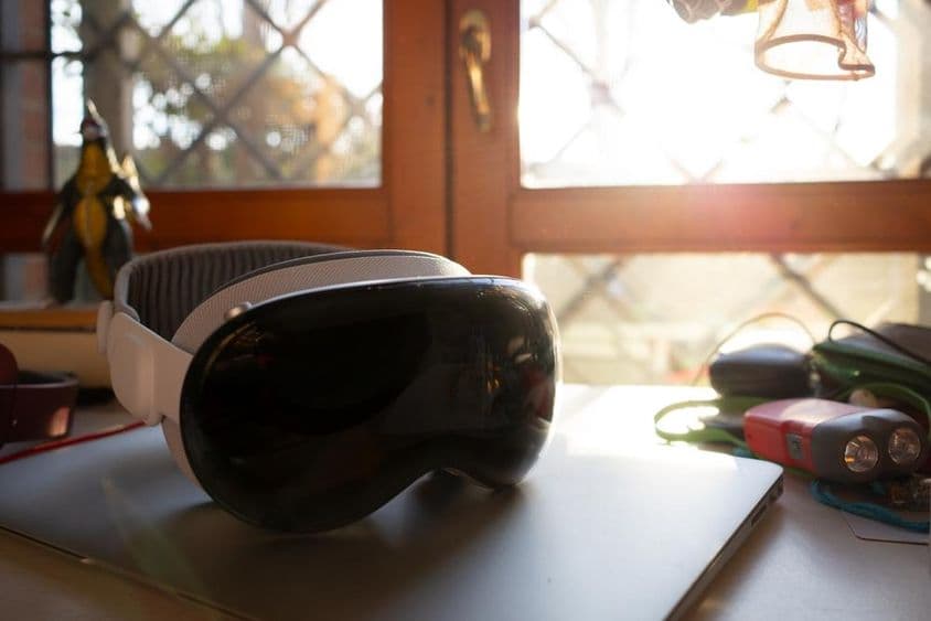 Apple Vision Pro fekszik egy notebookon egy asztalon.