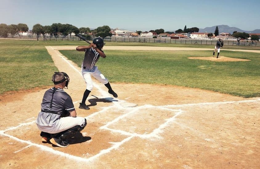 Egy baseball ütő játékos várja a labdát a dobótól.