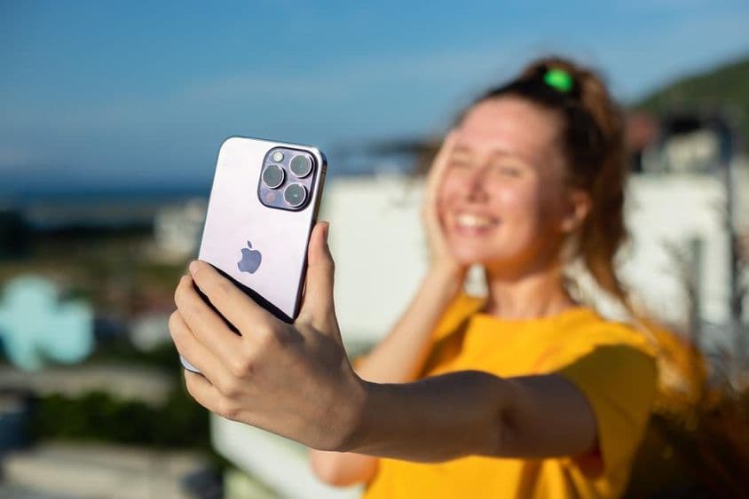 Fiatal lány kezében Iphone telefon.