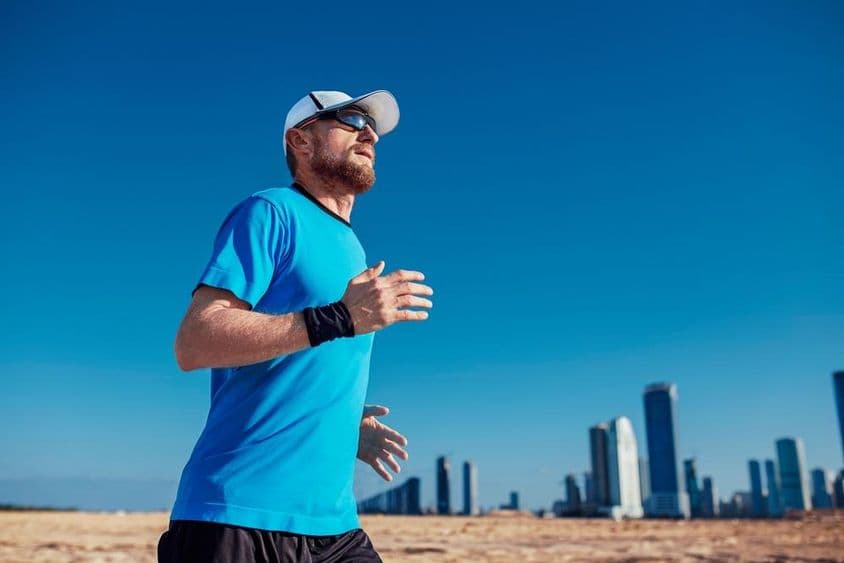 Dubai Triathlon, egy férfi fut, háttérben a felhő karcolok.