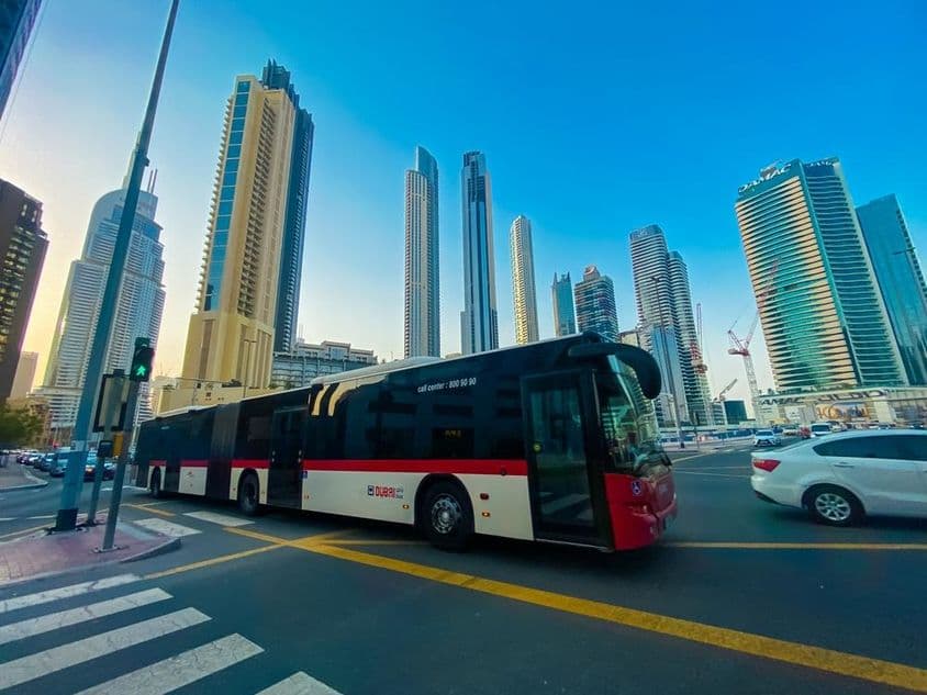 Dubai busz háttérben a felhőkarcolok.