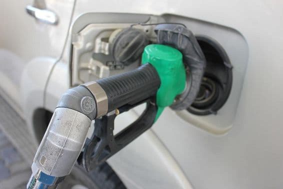 Tankolás benzinkúton egy fehér kocsiba.