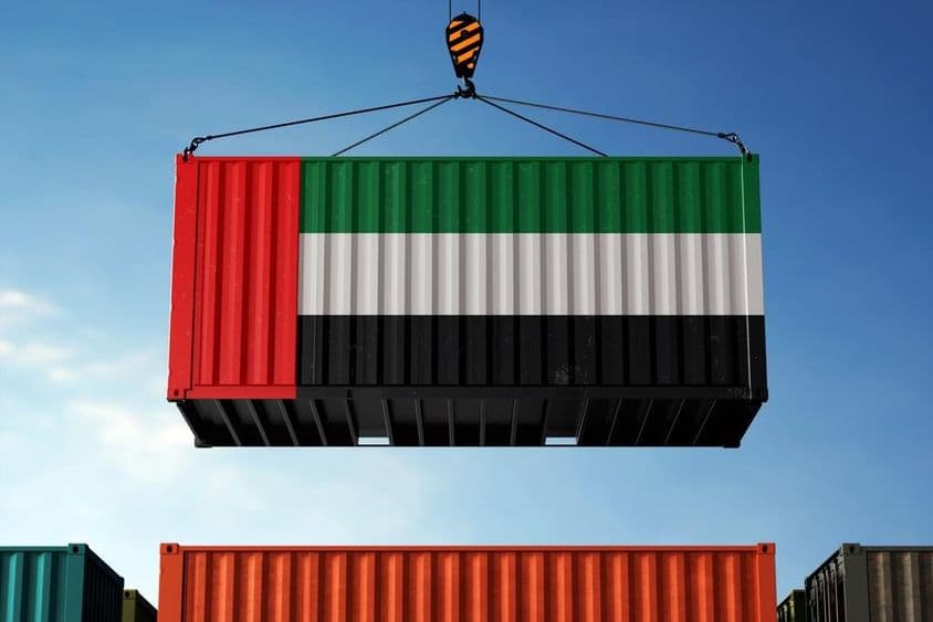 UAE zászló színeire festett konténert emel a daru.