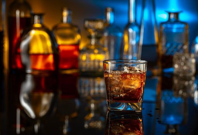 Whiskey jéggel egy fekete asztalon, egy bárban.