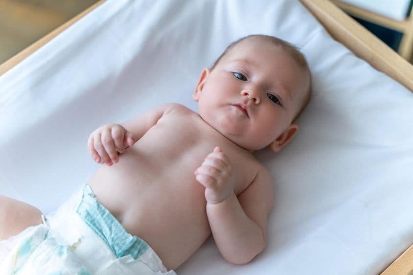 Fehér baba, fekszik pelenkában.