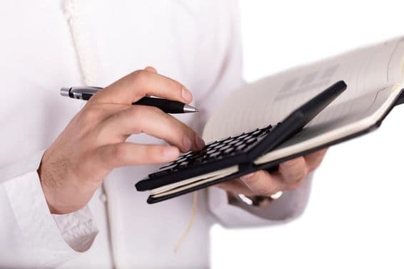 arab üzletember kezében számológép.