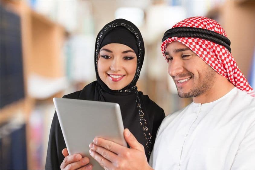 Arab diákok nézik a tananyagot egy tableten.