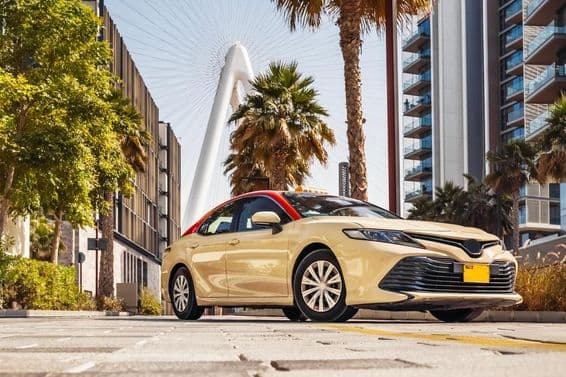 Dubai taxi, háttérben a pálmafákkal.