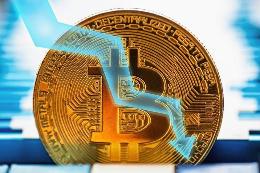 Arany Bitcoin érme - a kriptovaluta szimbóluma és a nyíl lefelé a technikai háttéren.