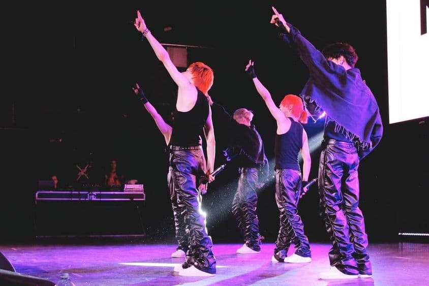 K-Pop együttes a színpadon táncol.