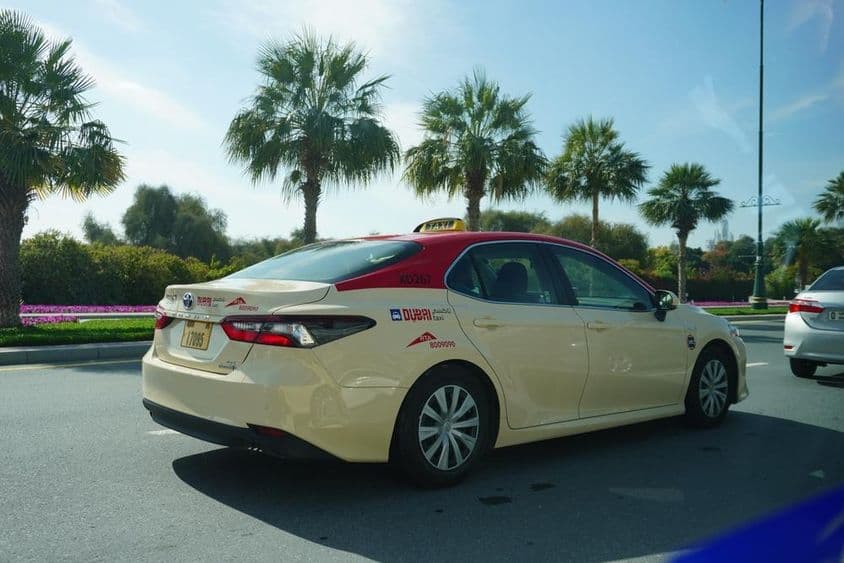 Dubai taxi piros tetővel az úton halad.