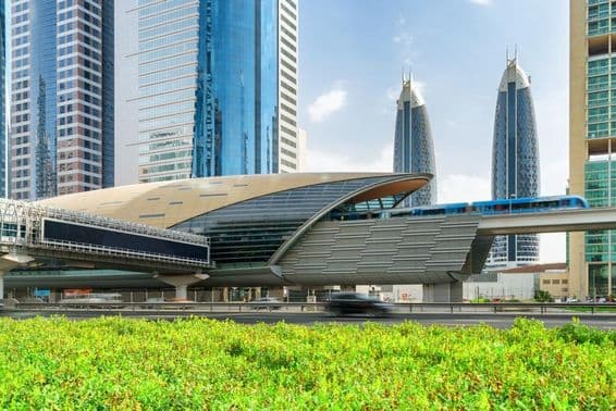 Adubaji metró, amint megérkezik a Financial Centre megállóba Dubai belvárosában, az Egyesült Arab Emírségekben a háttérben csodálatos felhőkarcolók láthatók.
