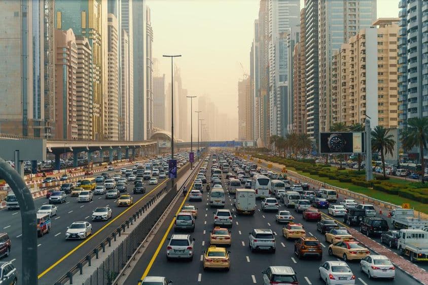 Csúcsforgalom sok autóval. Forgalmi dugó Dubai belvárosában, felhőkarcolók között.
