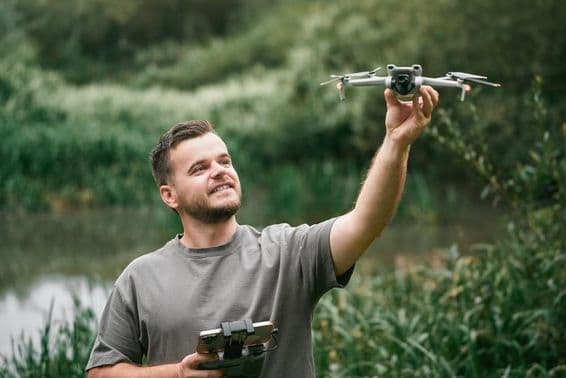 Drónpilóta tanár drónnal a kezében szabadtéri óra alatt.