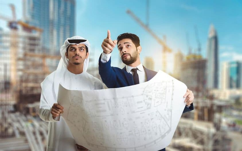 Építész magyarázza az arab építőknek az építkezés tervét