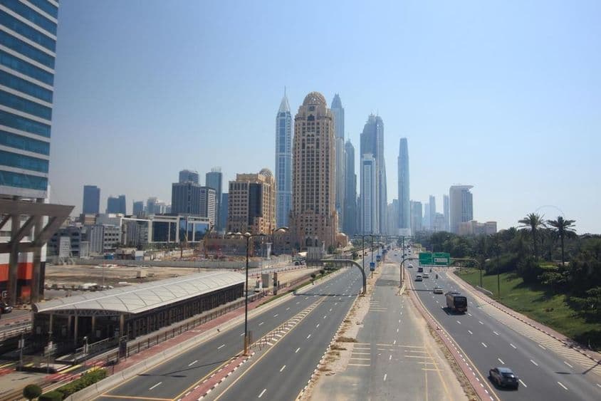 Dubai utcakép háttérben felhőkarolok és a villamos.
