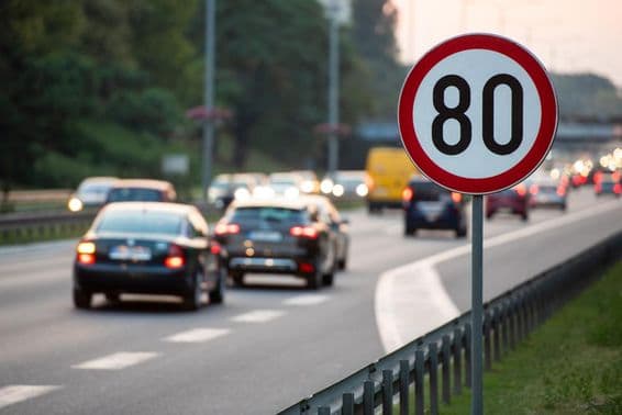 80km/h Sebességkorlátozó tábla egy autóval teli úton.