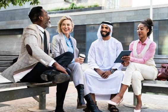 Üzletemberek csoportja, akik egy emírségi üzletemberrel találkoznak Dubaiban.