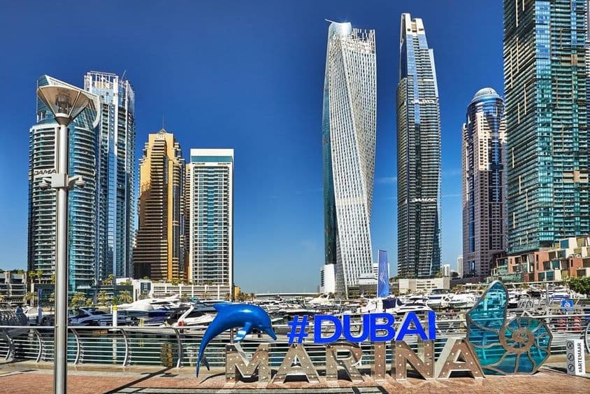 Felhőkarcolók és sétányok Dubai kikötőjében.