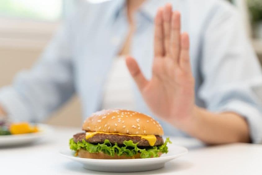 Egy nő megtagadja a gyorsétterem hamburgert, amely sok zsírt tartalmaz.