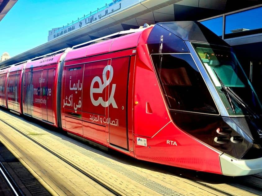 Egy piros villamos Etisalat reklámokkal.