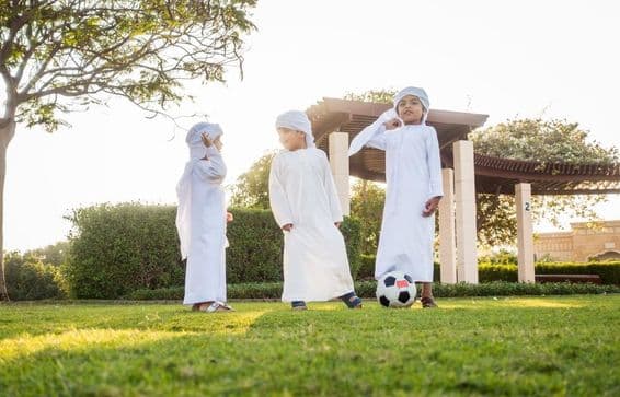 Közel-keleti gyerekek csoportja, akik játszanak és szórakoznak a szabadban.