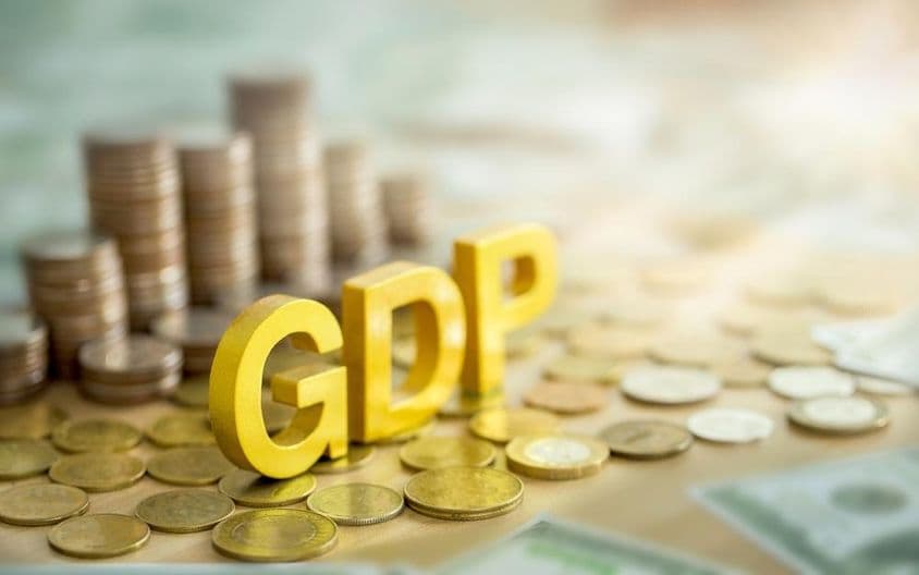 GDP felírat, a háttérben egy halom érme.