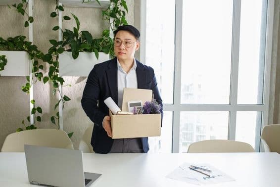 Egy férfit kirúgnak a munkahelyéről, és kartondobozba csomagolja a személyes dolait.