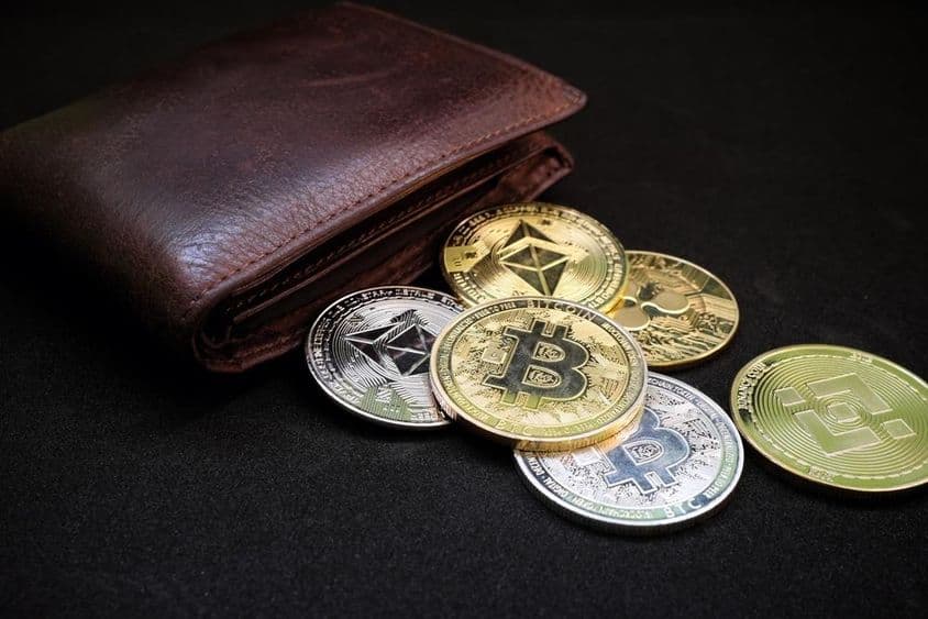 Pénztárca különböző kriptoérmékkel, például bitcoinnal és ethereummal, fekete háttéren.