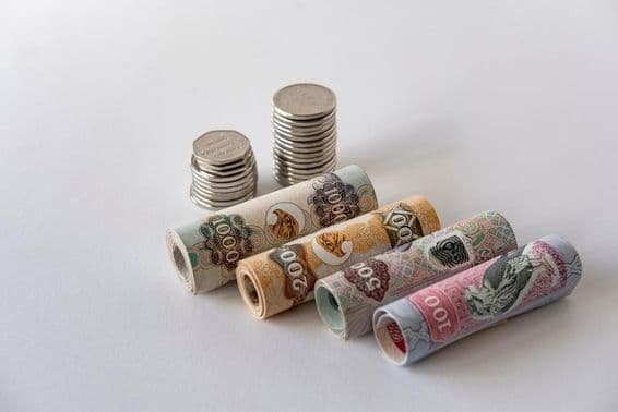 Az Egyesült Arab Emírségek dirham valutája és érmék gyűjteménye feltekerve és egymásra rakva.