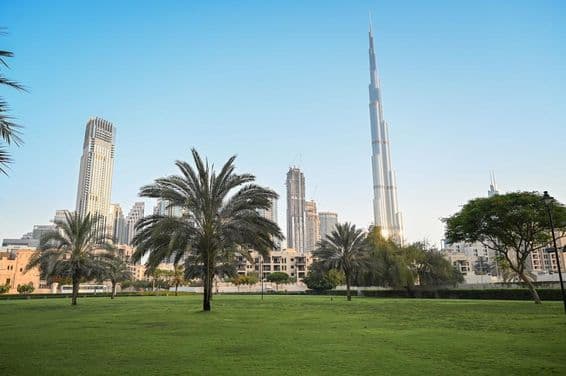 Dubai, Egyesült Arab Emírségek, zöld park lakónegyedben, burj khalifa a háttérben.