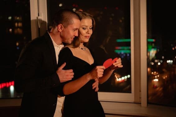 Szerelmes pár randevúzva az ablak mellett állva, Valentin-napon.