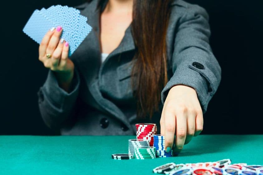 Blackjack egy kaszinóban, egy nő fogadást köt, és berak egy zsetont.