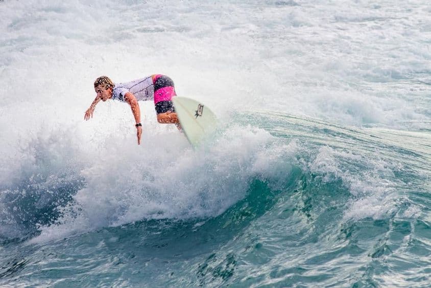 Fiatal srác szörfözik egy nagy hullámon.