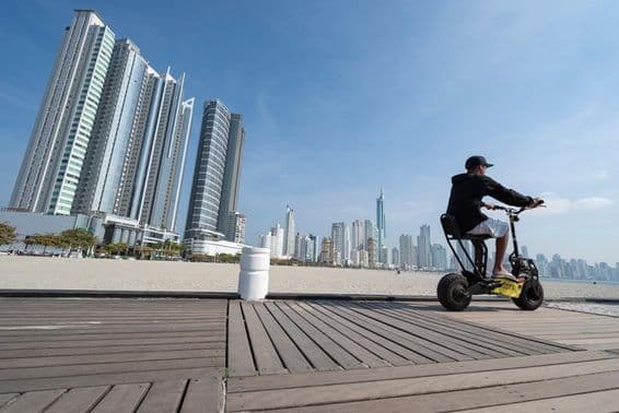 Fiatal férfi robogóval vezet.