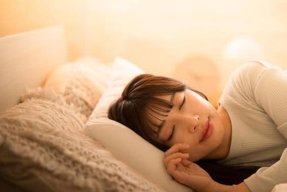 Egy nő ágyban alszik.
