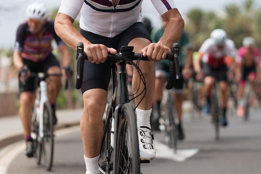 Kerékpáros sportolók versenyeznek egy utcán.