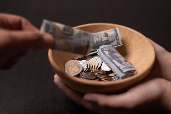 Adomány gyűjtése egy fa edénybe.