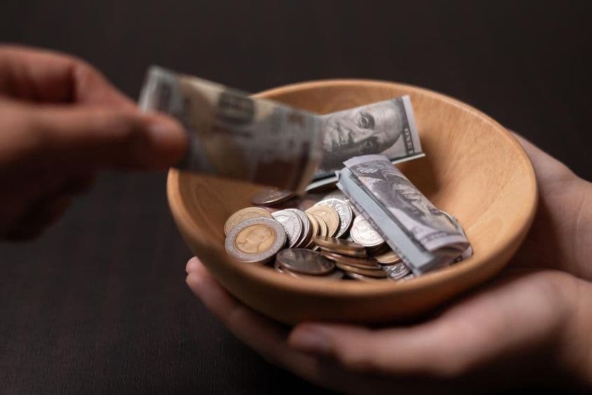 Adomány gyűjtése egy fa edénybe.