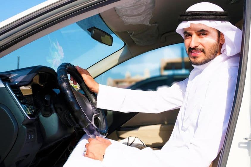 Magabiztos arab sofőr mosolyogva.